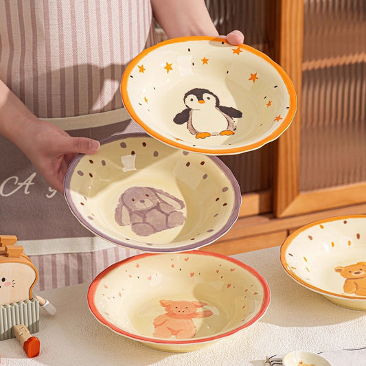 Set of ceramic bowls with animal illustrations held by a person.