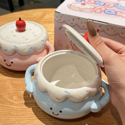 Ceramic container shaped like a cake with a lid, held by a hand on a wooden surface.