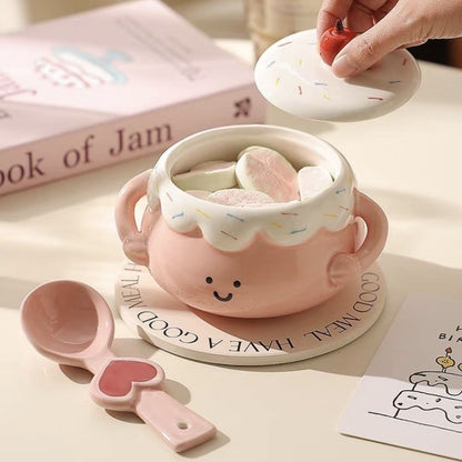 Cute pink ceramic mug with a lid, spoon, and heart-shaped design on a light surface.