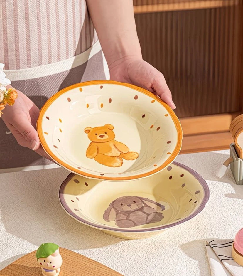 a ceramic bowl with a teddy bear design on a light surface.