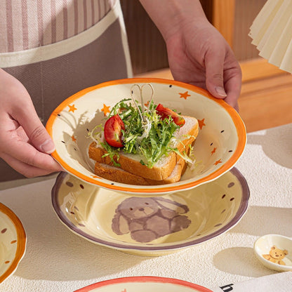 Person holding a plate with a sandwich and salad on a table with a teddy bear design.