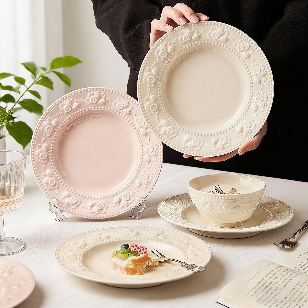 Two 8-inch ceramic plates with embossed floral borders in pastel pink and cream white, featuring a croissant on the pink plate.